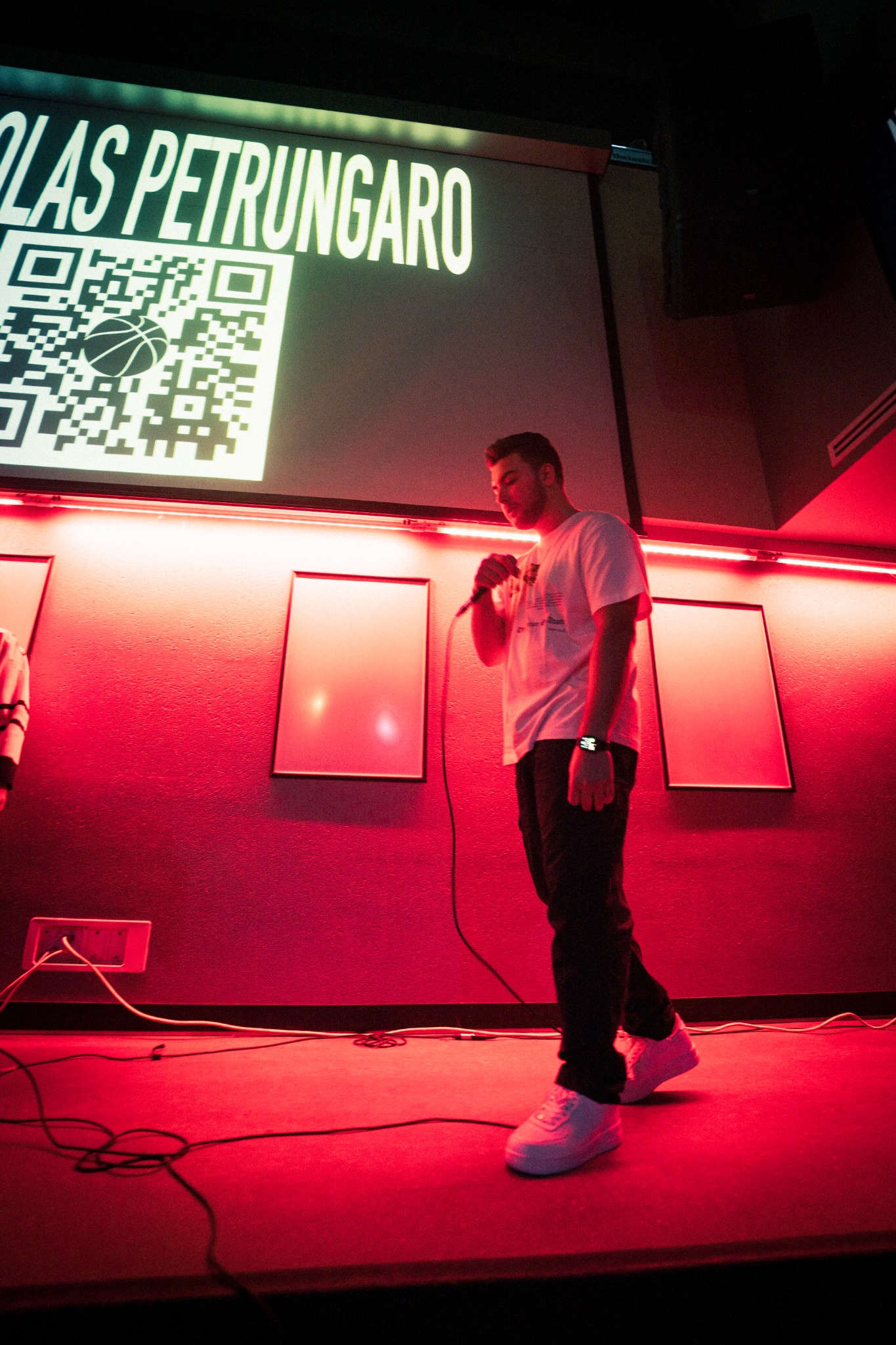 Nicholas Petrungaro performing under red stage lights